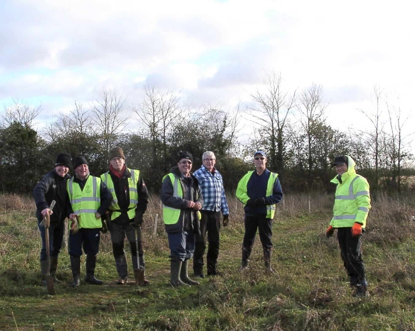 smiling volunteers pose in a field