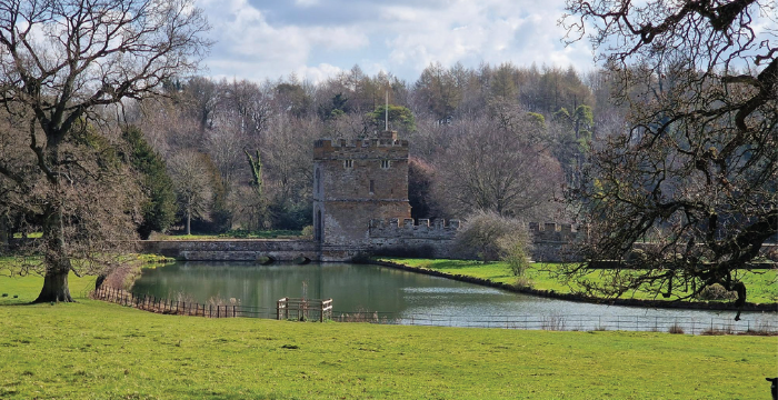Imposing castle surrounded by moat and green fields
