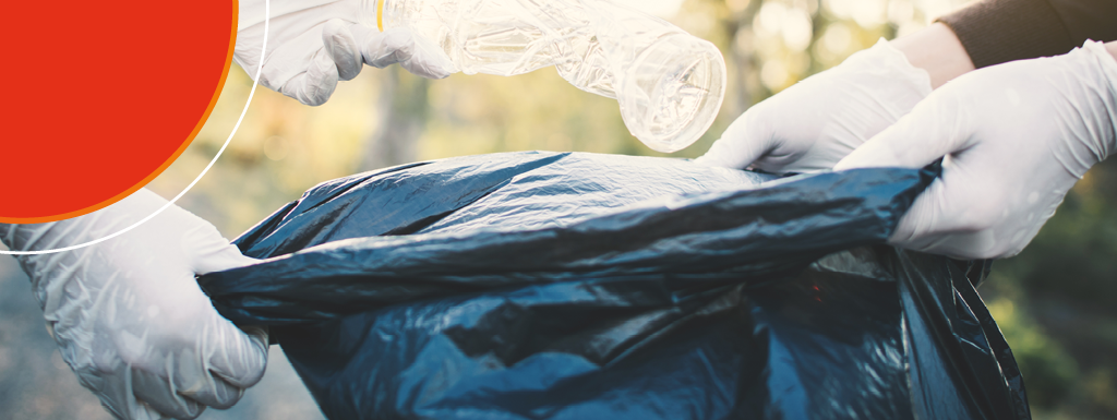 two people putting rubbish into a bin bag