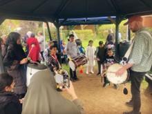 Group of people playing assortment of musical instruments in the garden