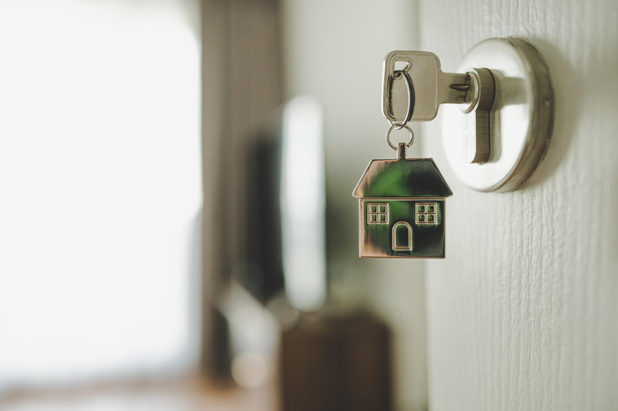 An image of a key in a door to represent a home