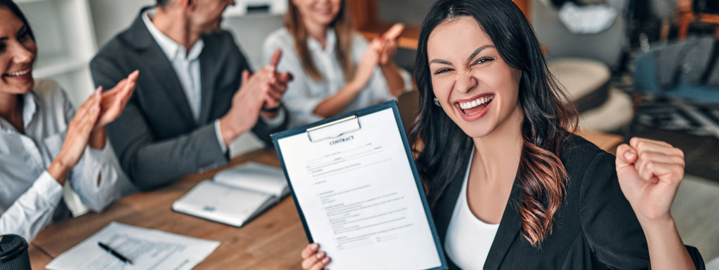 Woman holding a job application form standing in front of a group of people