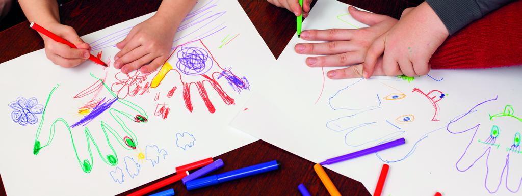 Children's hands hovering over drawing