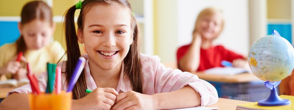 School girl sat at desk in school