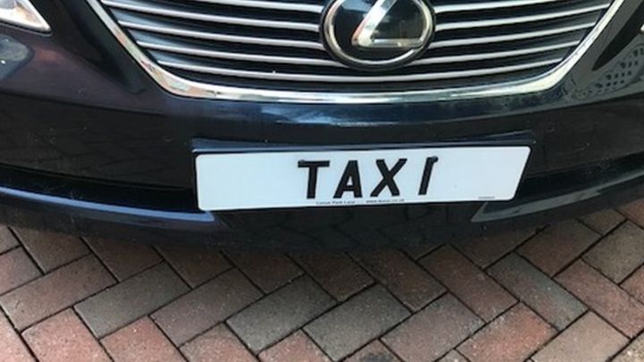 Taxi number plate on car