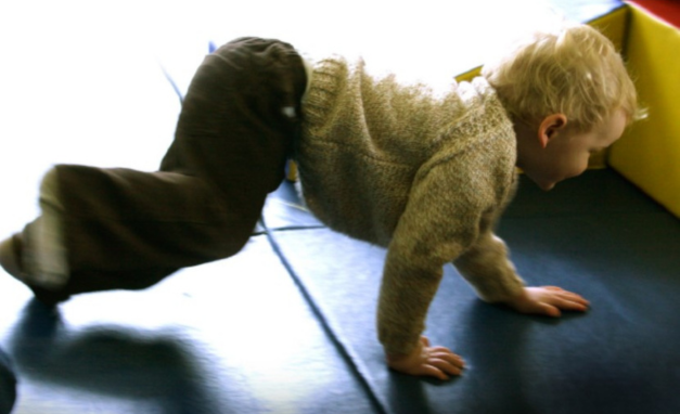 Young child crawling on a play mat