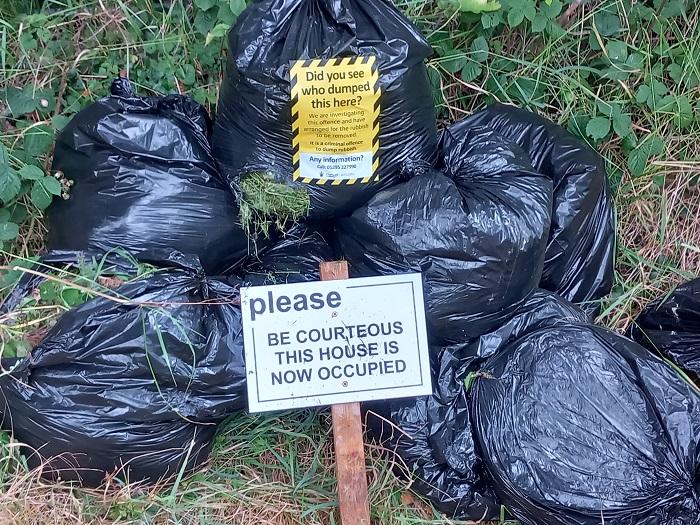 Black waste bags including a distinctive sign