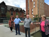 Four councillors standing on the new bridge with the hotel in the background