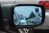 this car wing mirror shows a line of queuing traffic