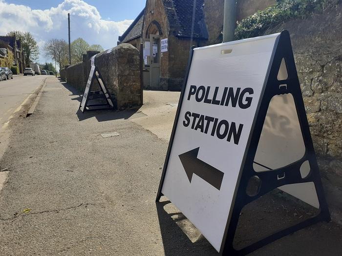 signs point to the polling station entrance in Bodicote, 2021