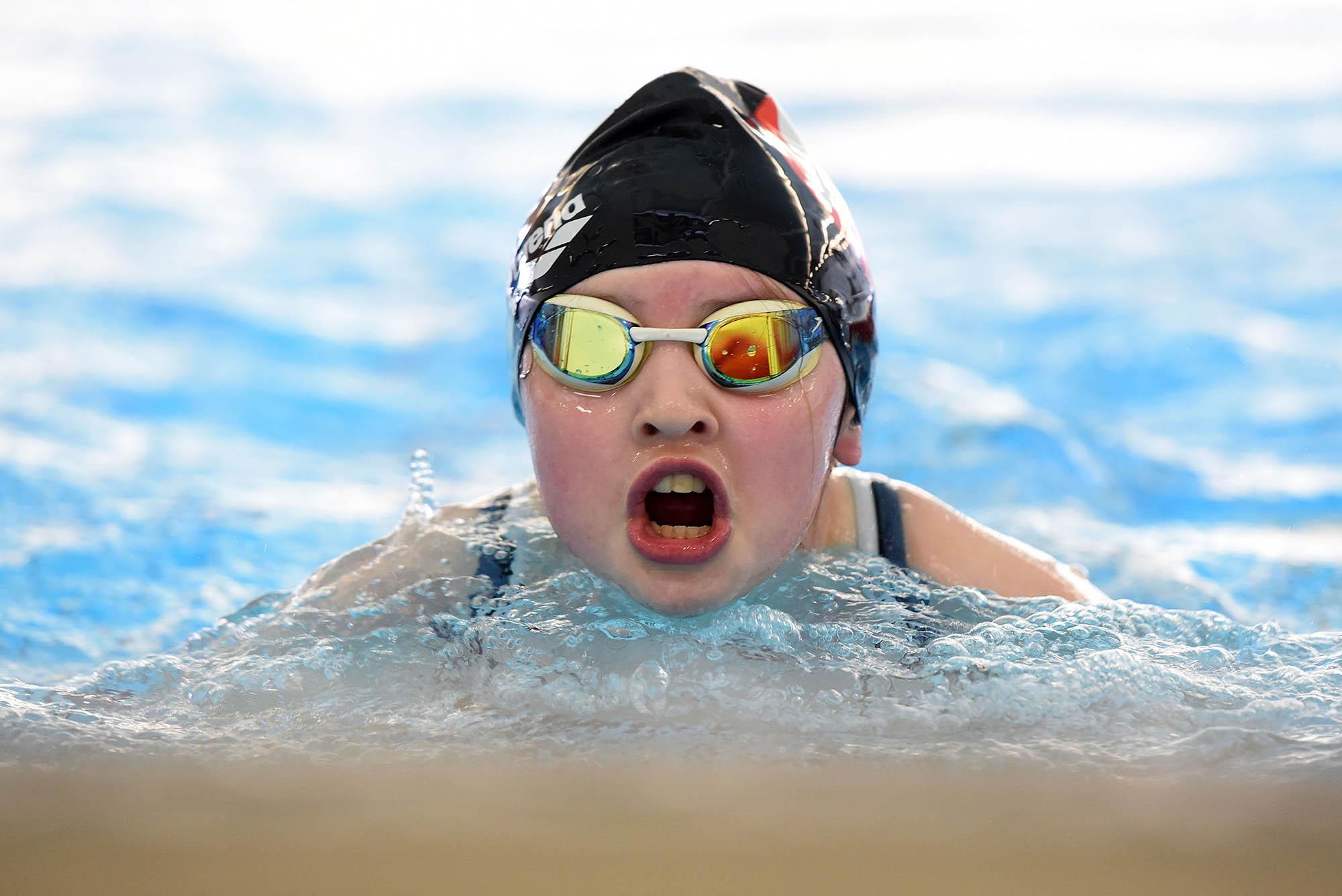 this girl is in th eswimming pool with goggles and a cap
